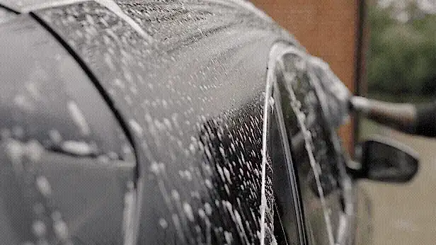 Microfibre wash mitt gliding over bonnet with soapy water